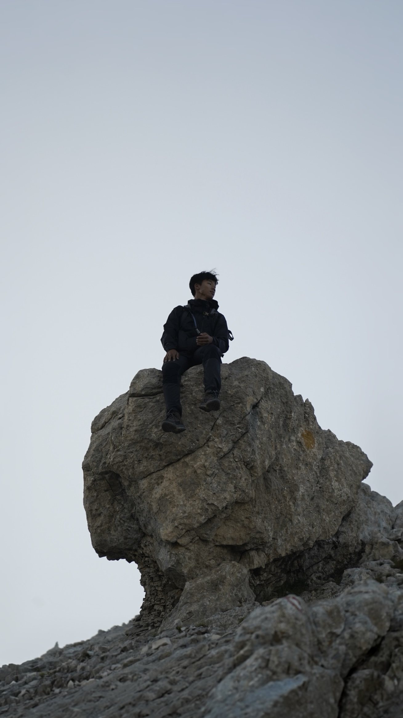 Toan seduto su un masso in montagna